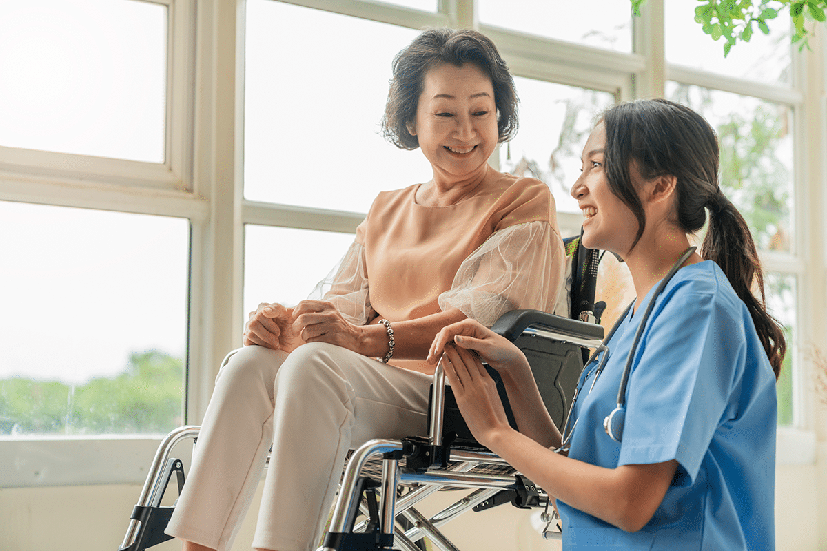 asian young caregiver caring her elderly patient senior daycare handicap patient wheelchair hospital talking friendly nurse looking cheerful nurse wheeling senior patient 1