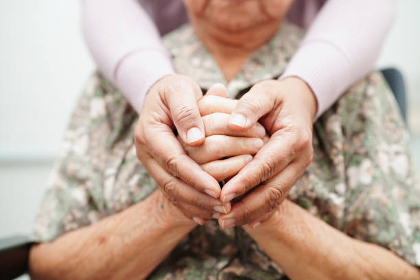 caregiver holding hands asian elderly woman patient, help and care in hospital.